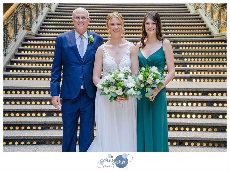 Bride with her family in front of the lit staircase at the Hyatt Regency Cleveland at The Arcade in Ohio