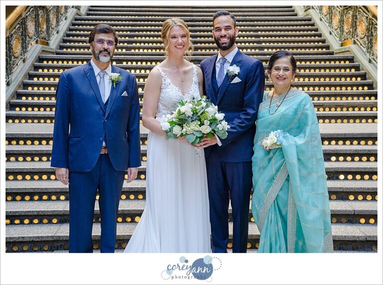 Bride and groom with his family in front of the lit staircase at the Hyatt Regency Cleveland at The Arcade in Ohio