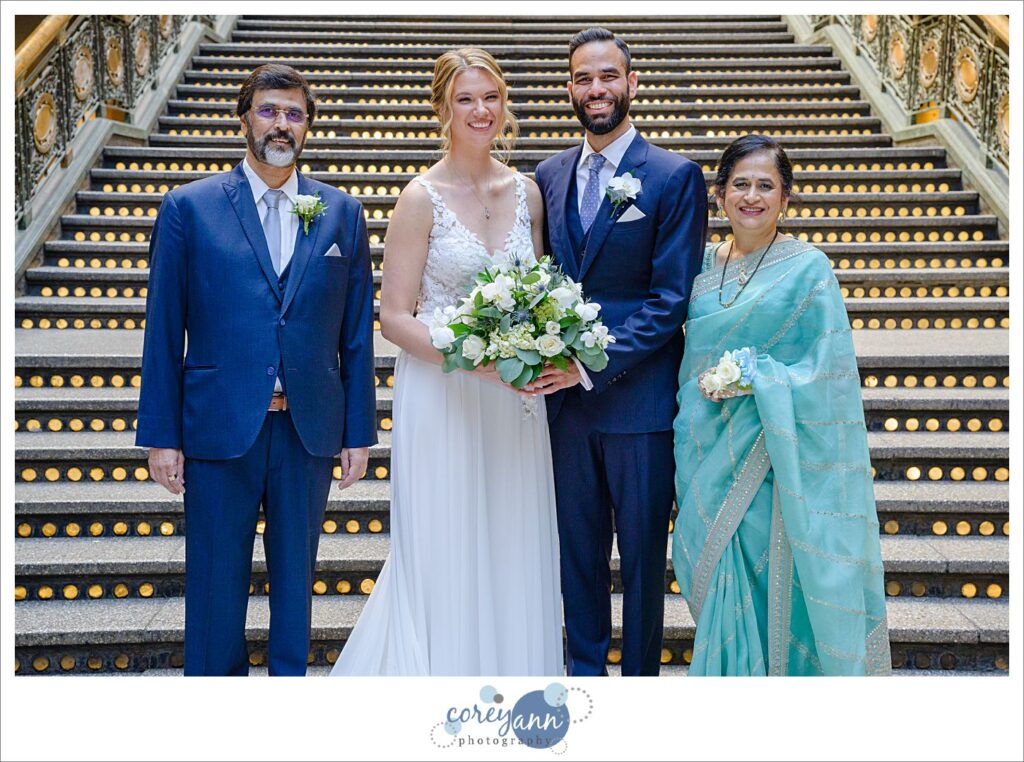 Bride and groom with his family in front of the lit staircase at the Hyatt Regency Cleveland at The Arcade in Ohio