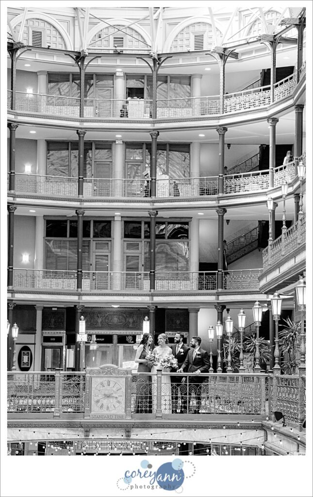 Bridal party standing on bridge at The Arcade in Cleveland in black and white