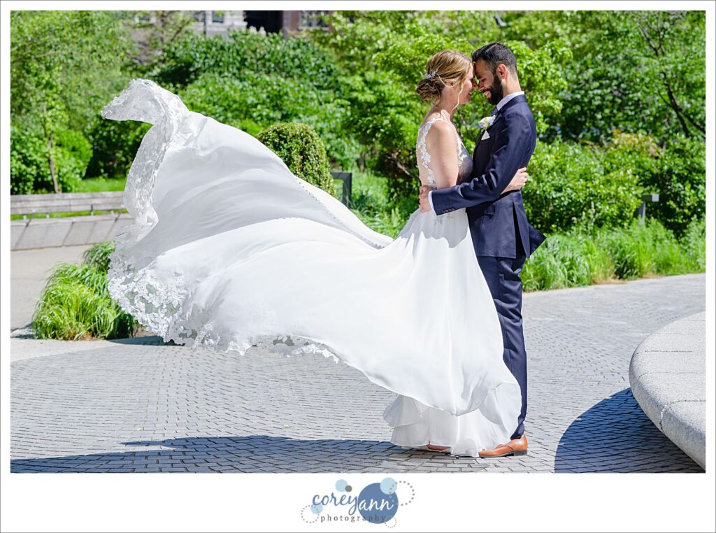 Bride and groom looking at each other and having dress thrown behind the bride in Cleveland's Public Square