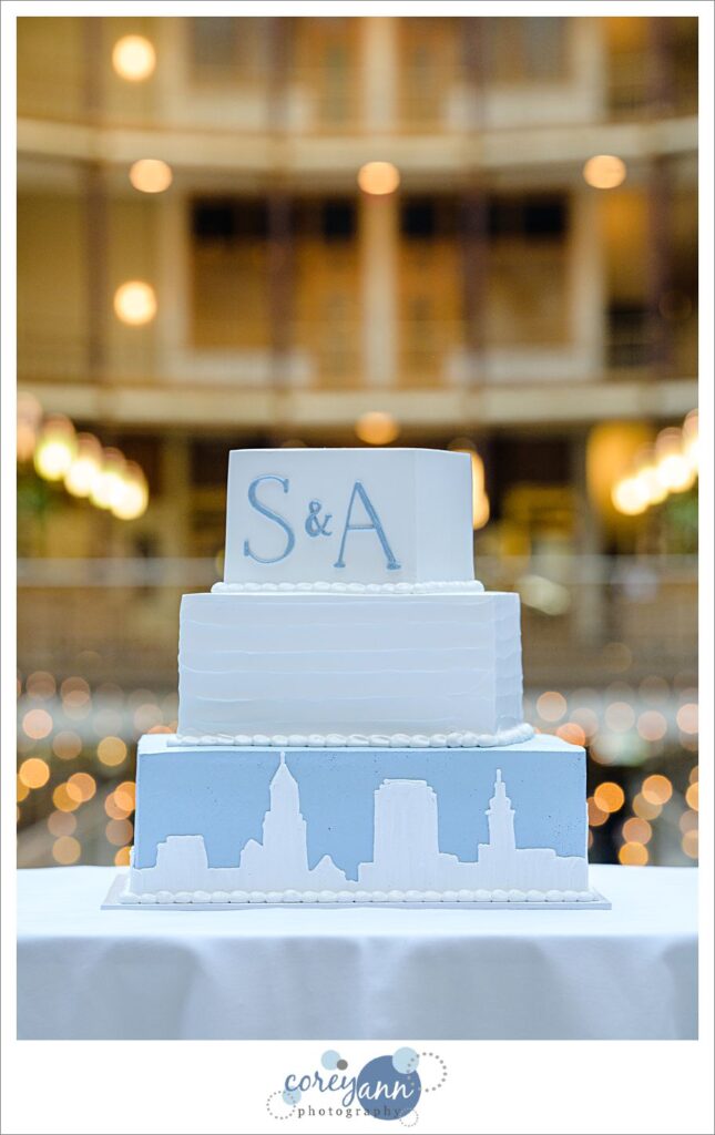 Blue and white wedding cake with skyline at Hyatt Regency Cleveland at The Arcade by Wild Flour Bakery