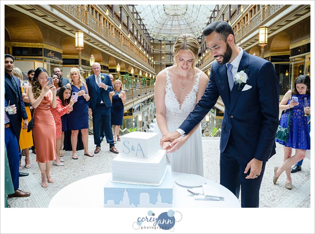 Bride and groom smiling cutting their cake at Hyatt Regency Cleveland at The Arcade 