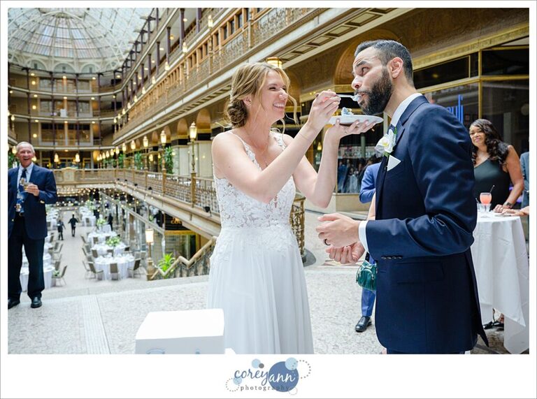 Bride and groom smiling cutting their cake at Hyatt Regency Cleveland at The Arcade 