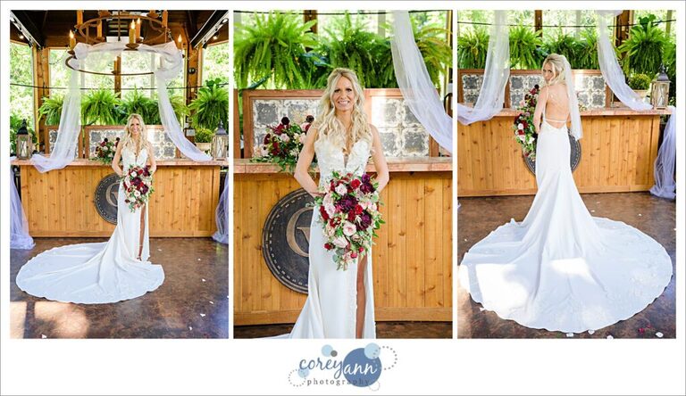 Bride in a stunning white Jovani wedding dress holding a red and pink floral bouquet at Gervasi Vineyard