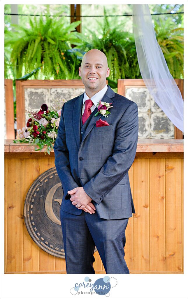 Groom in a grey suit with red tie after ceremony at Gervasi Vineyard