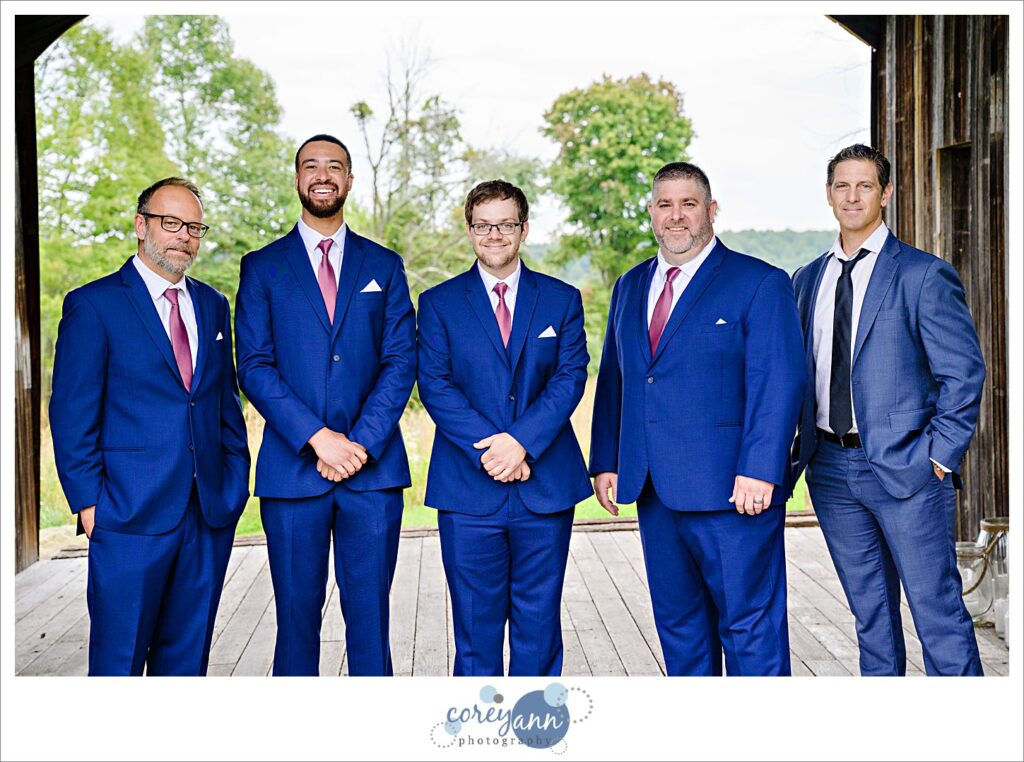 Groom and groomsman in blue suits with pink ties for wedding in Ohio