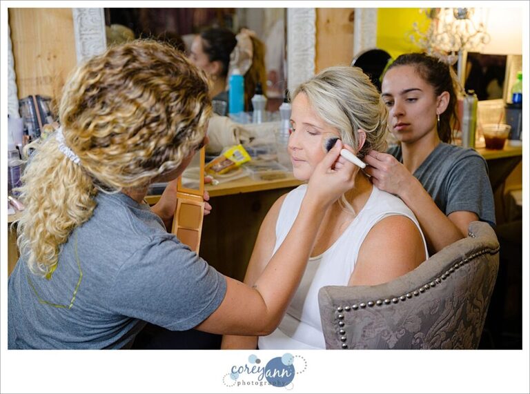 Bride getting hair and makeup done before wedding at Barn on Enchanted Acres