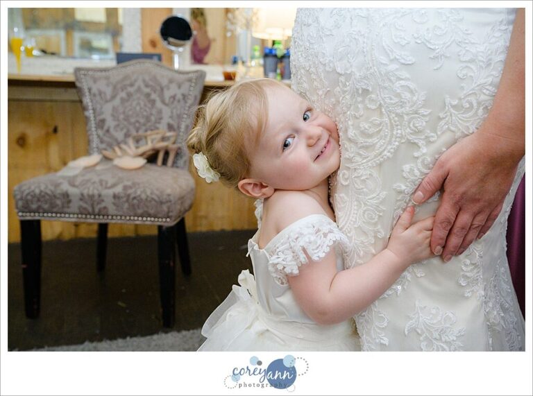 Bride's daughter hugging her as she get dressed before wedding in Dennison Ohio