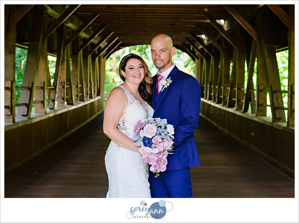 Bride and groom pose on the covered bridge in Olmsted Falls Ohio after their wedding 