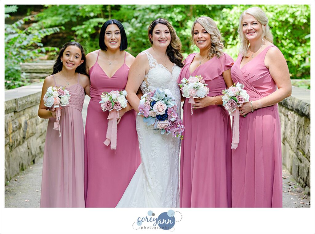 Bride with bridemaids in varying pink dresses after wedding in Olmsted Falls Ohio