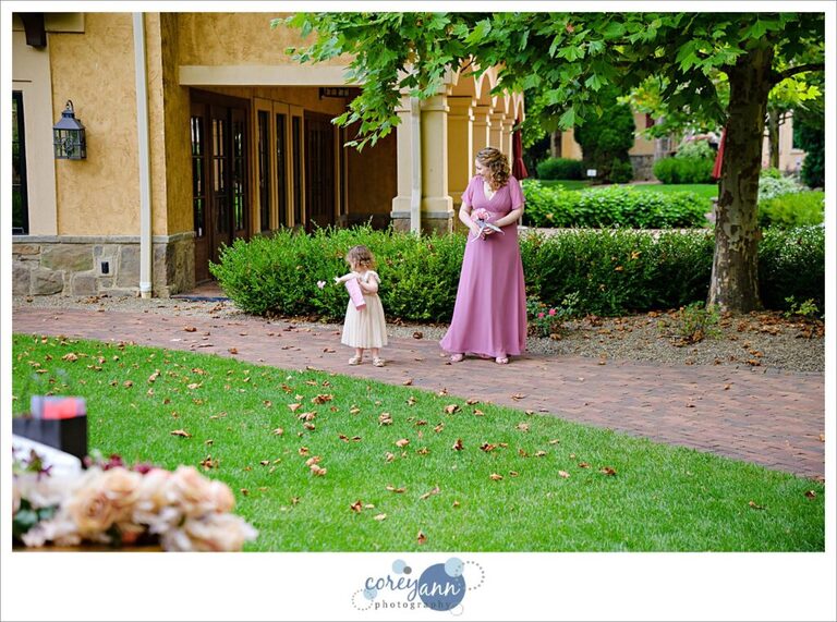 Flower girl tossing petals on the ground on the way down the aisle at Gervasi Vineyard