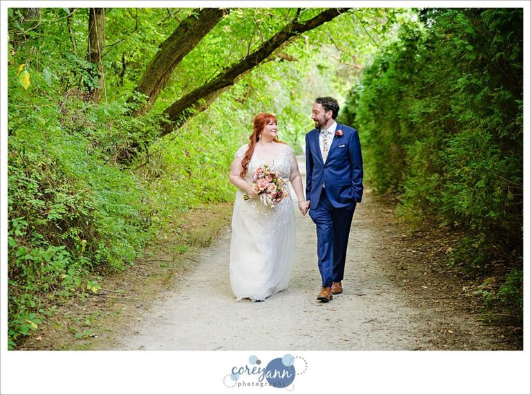 Bride and groom walking on wooded trail near Gervasi Vineyard in Canton Ohio 