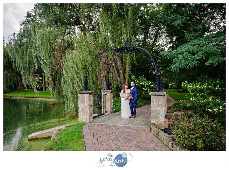 Bride and groom posing on the bridge at Gervasi Vineyard in Canton Ohio after their wedding ceremony