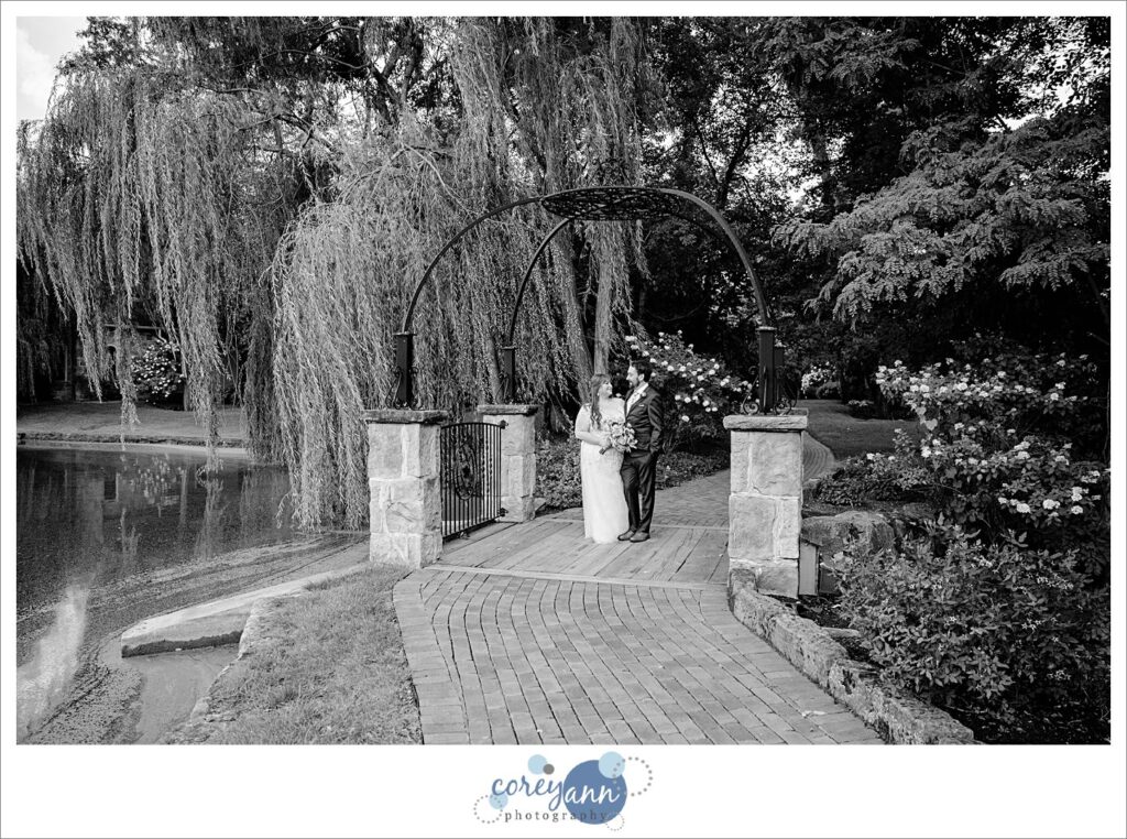 Bride and groom posing on the bridge at Gervasi Vineyard in Canton Ohio after their wedding ceremony