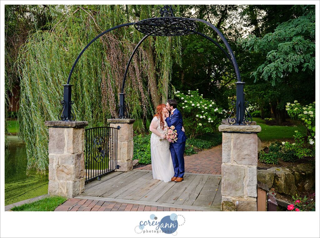 Bride and groom posing on the bridge at Gervasi Vineyard in Canton Ohio after their wedding ceremony