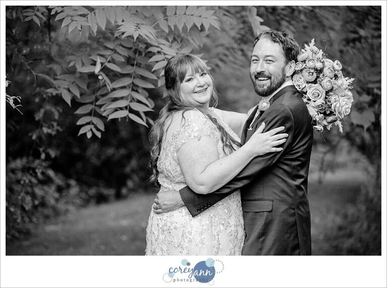 Black and white portrait of a bride and groom laughing with each other after their wedding at Gervasi Vineyard
