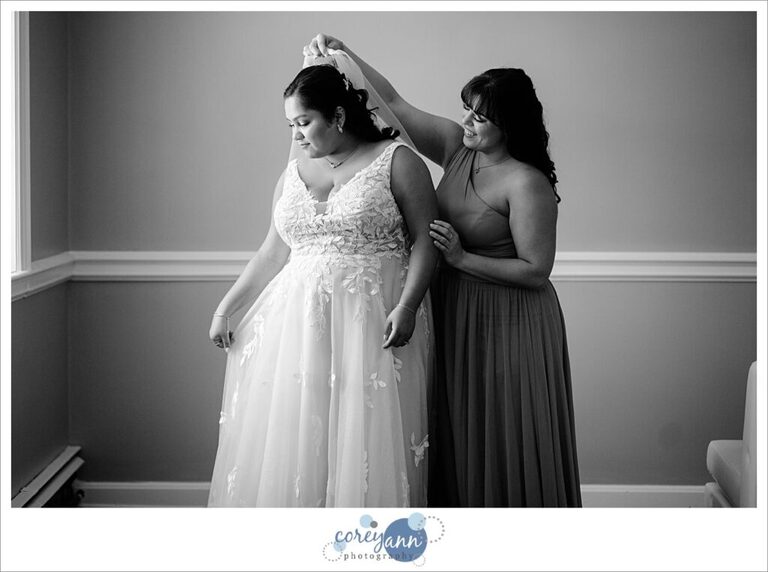 bride getting dressed for her wedding at manakiki golf course in  Willoughby Ohio