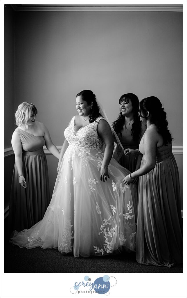 bride getting dressed for her wedding at manakiki golf course in  Willoughby Ohio