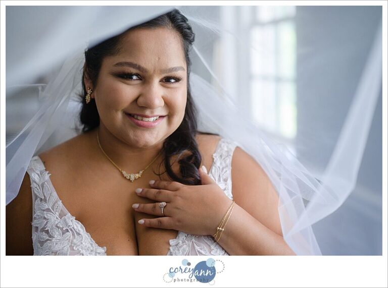 bride getting dressed for her wedding at manakiki golf course in  Willoughby Ohio