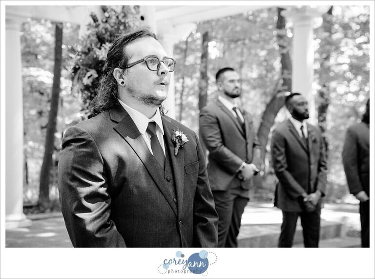 Black and white photo of a groom saying wow when seeing his bride for the first time in Ohio