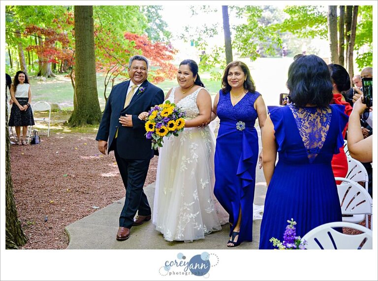 Bride and her parents walk up the aisle for the wedding ceremony in Willoughby Ohio