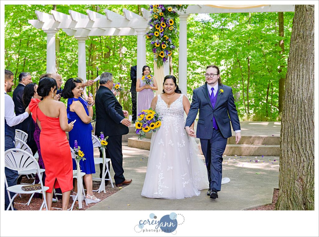 Lavender being tossed at newlyweds as they walk down the aisle after wedding ceremony at Manakiki Golf Course