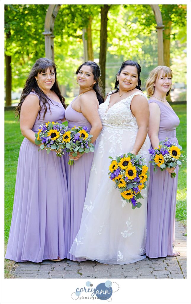 Bride and bridesmaids posing side by side at Coulby Park in Ohio