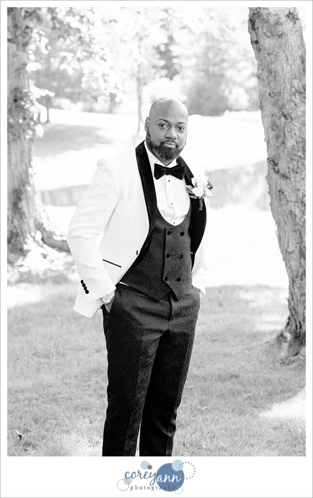 Groom wearing a white tux jacket with black bow tie and vest