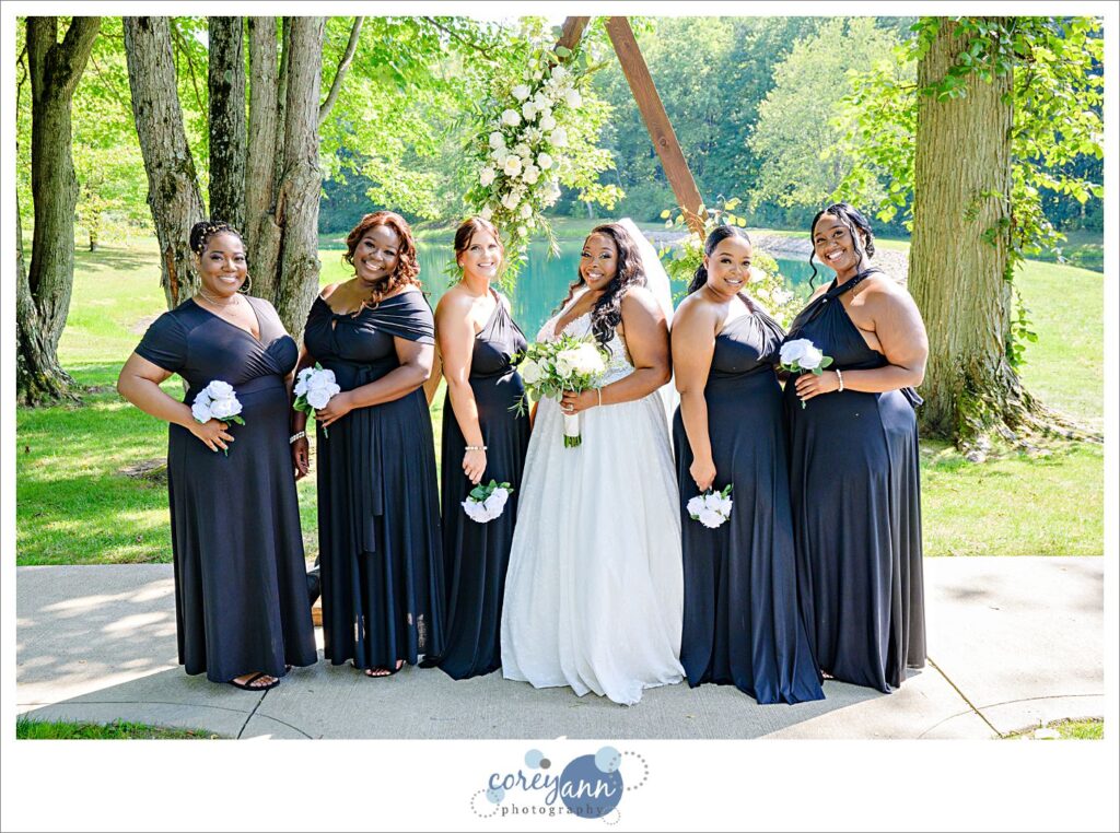 Bride and her bridesmaids posing in front of arch at Sun Valley Ohio