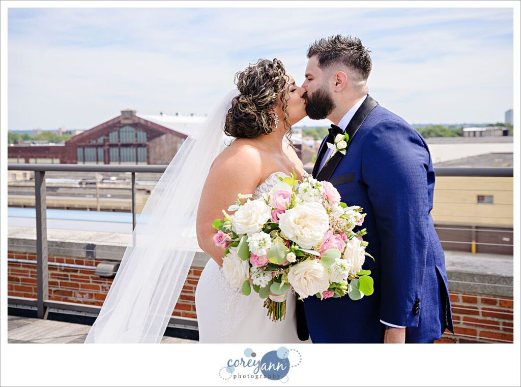 Bride and Groom kissing after first look on the rooftop at the Ariel International Center in Cleveland