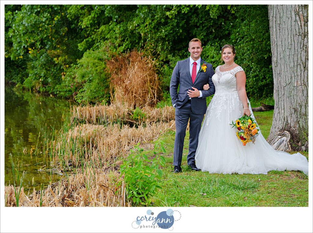 Bride and Groom standing beside Nimisila Reservoir on a September day before their wedding in Akron