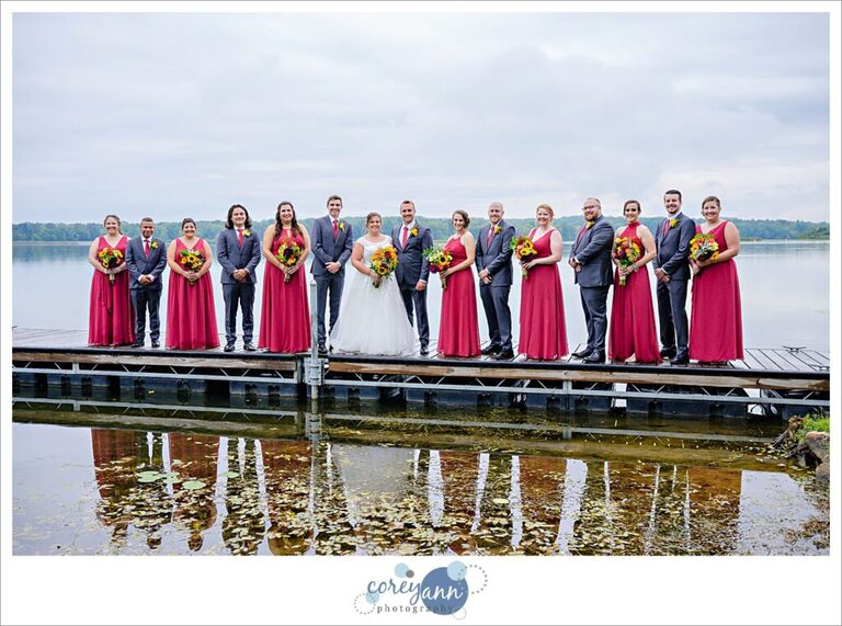 bridal party standing on a dock on portage lakes wearing red and black