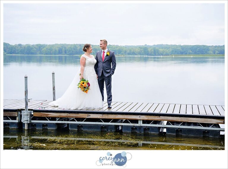 Bride and Groom standing on a dock on Nimisila Reservoir before wedding in Akron