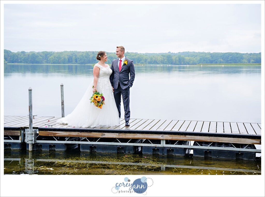 Bride and Groom standing on a dock on Nimisila Reservoir before wedding in Akron
