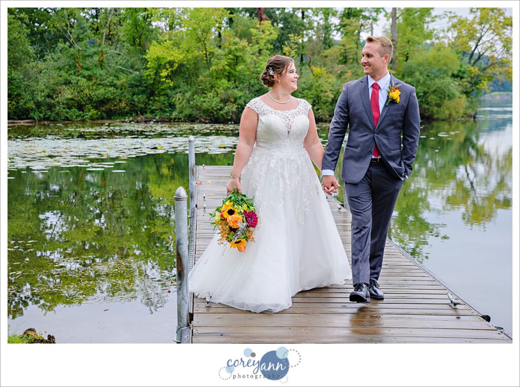 Bride and Groom walking on a dock on Nimisila Reservoir before wedding in Akron