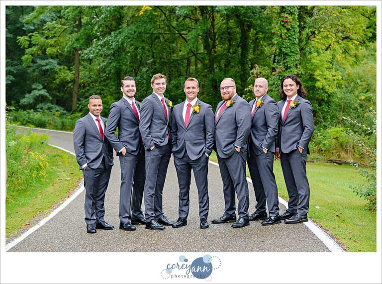 Groom and groomsman in grey suits with red ties before wedding in Akron Ohio