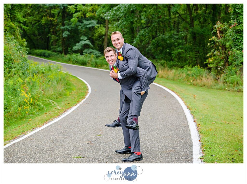 Groom doing a fun pose with a groomsman showing off their fun socks