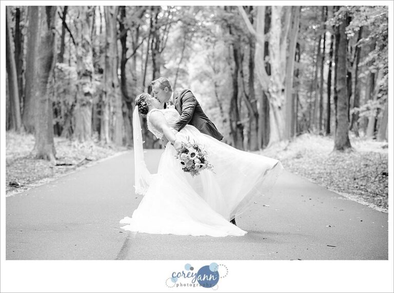 bride and groom doing a dip on a forest road in akron ohio