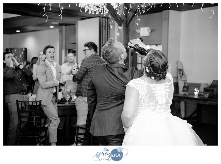 Bride and Groom chugging beer after introduction into wedding reception at Gather at the Lake