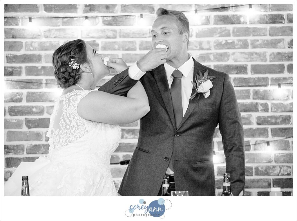 Bride and groom eating cupcakes at the same time during wedding reception