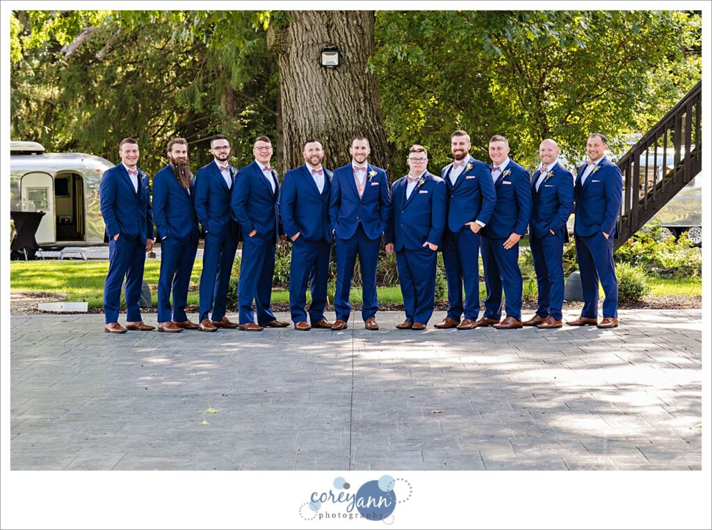 Groom and Groomsman in blue suits with pink ties before wedding in Akron Ohio