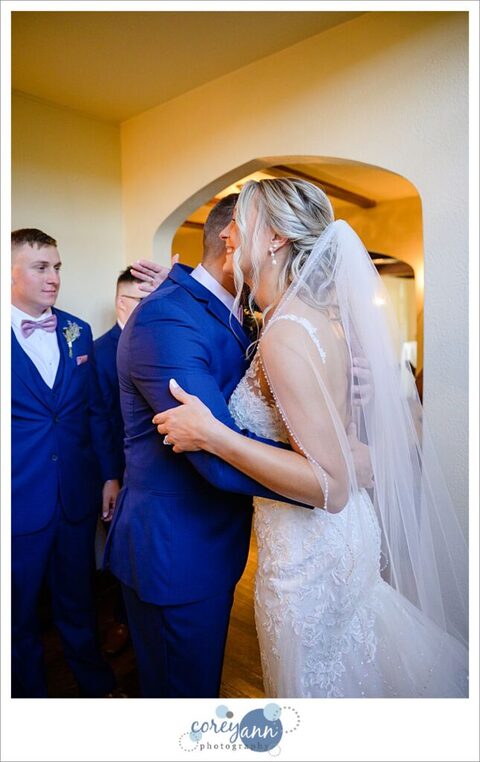 Bride doing first look with her brothers at Tudor House on Mason's Cove on Portage Lakes in Akron Ohio