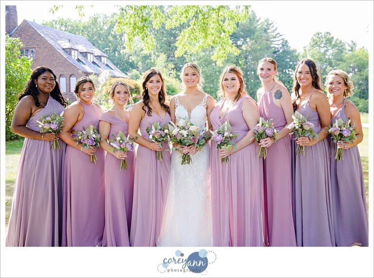 Bride alongside bridesmaids in Azazie dresses in pink and purple