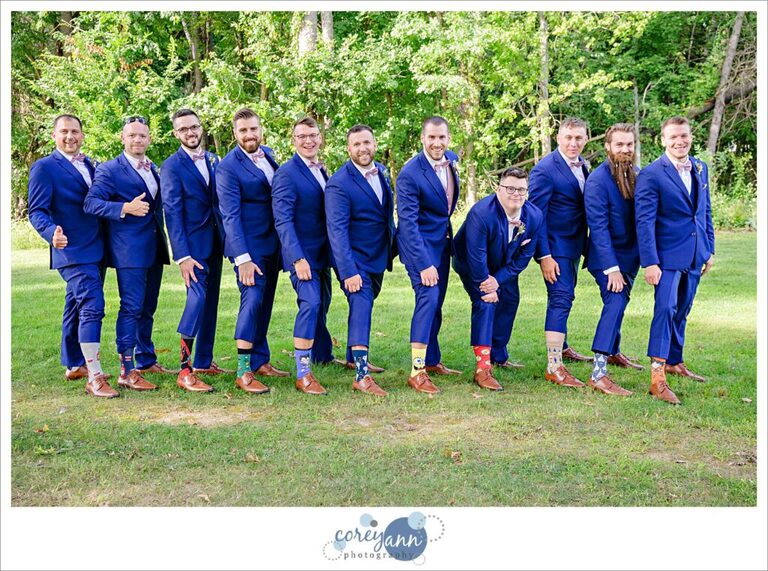 Groom and groomsman in blue suits showing off their fun socks