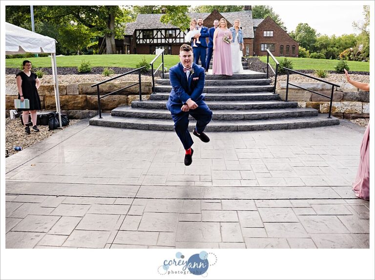 Groomsman dancing during wedding reception entrance at Tudor House on Portage Lakes