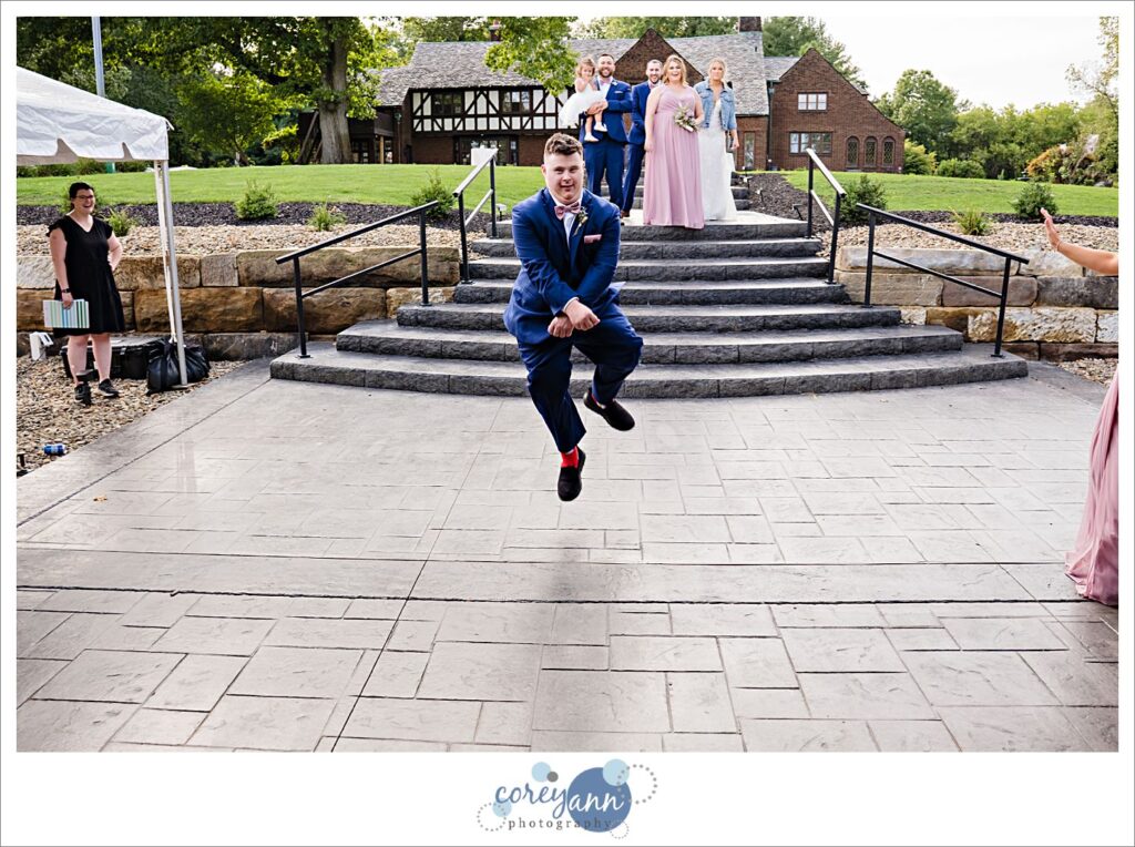 Groomsman dancing during wedding reception entrance at Tudor House on Portage Lakes