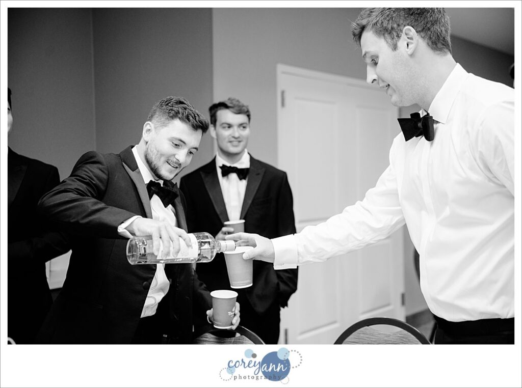 Groomsman pouring a drink before wedding ceremony in Avon Ohio