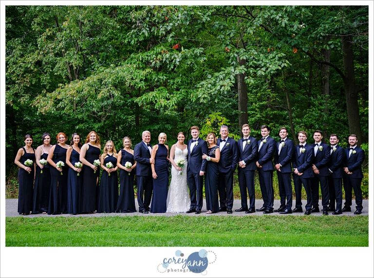 Parents, bridal party and bride and groom pose for a portrait at Huntington Reservation in Ohio