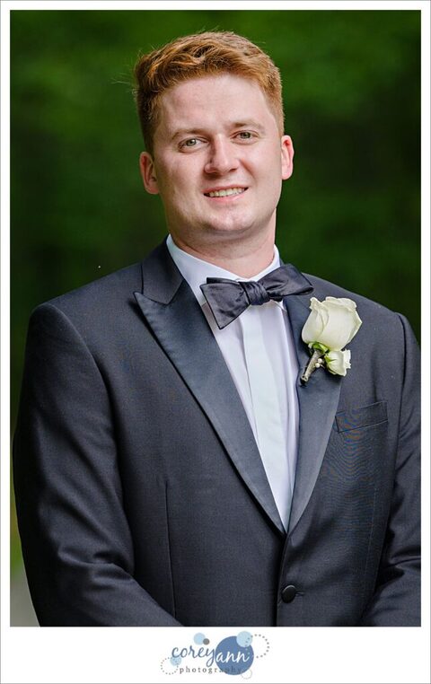 Groom posing while wearing black tux for wedding in Avon Ohio